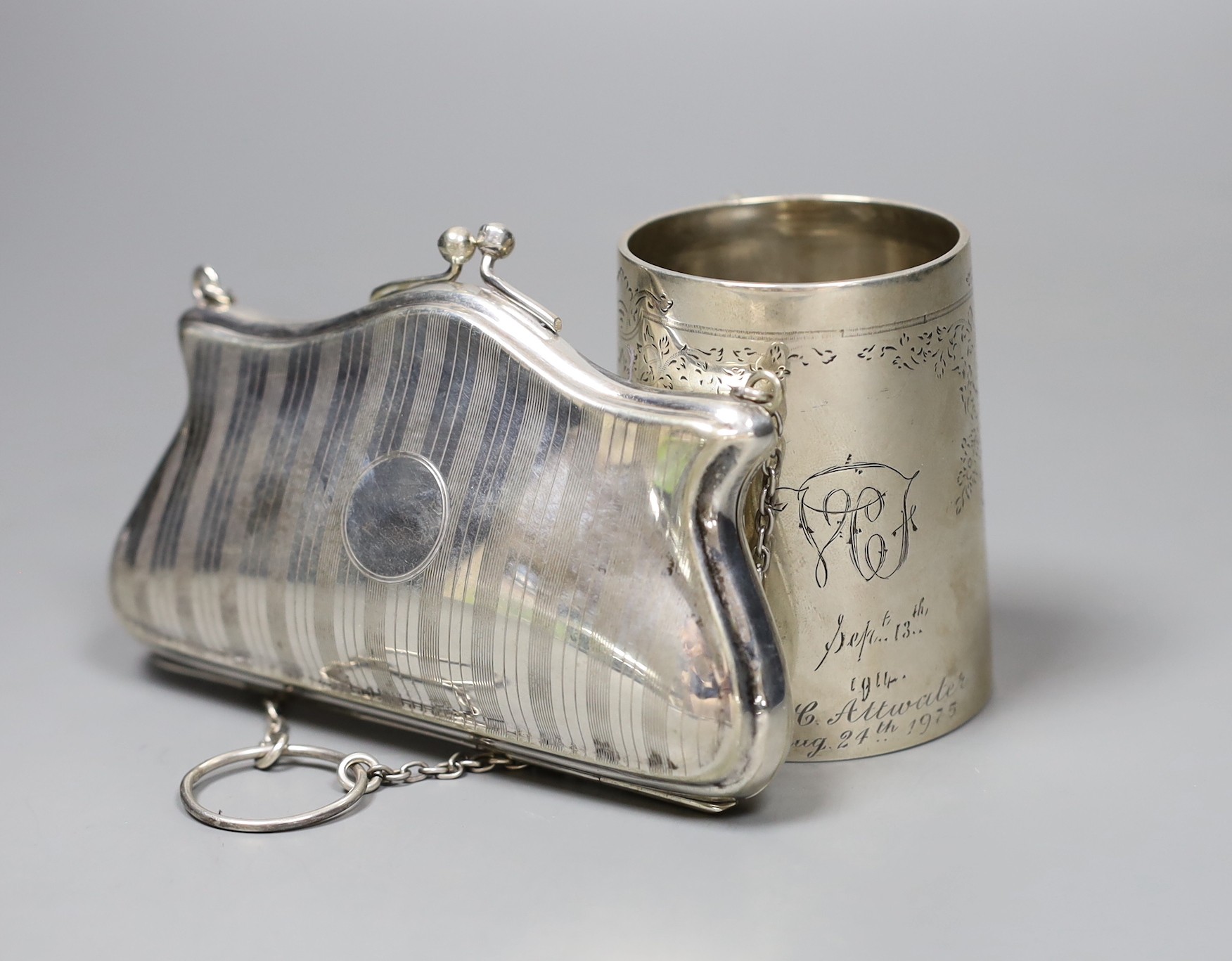 A Victorian engraved silver christening mug, London 1889, 72mm., and a plated evening purse